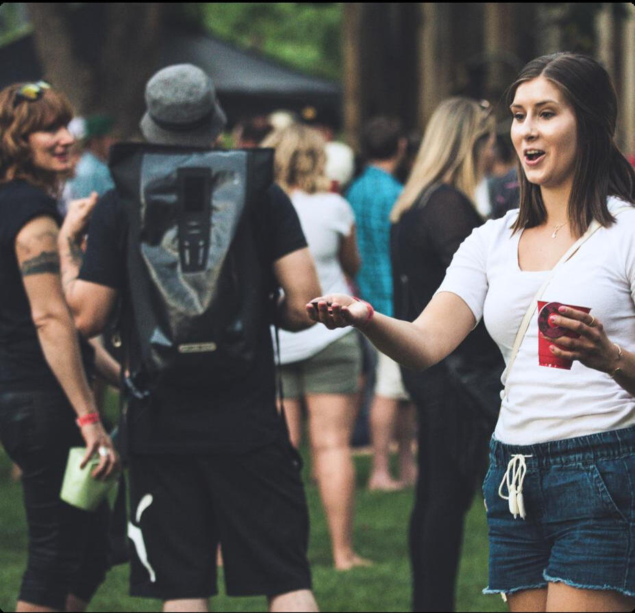 Lively apartment community festival with Resident Roots Young woman smiling and holding a drink at a vibrant apartment community gathering hosted by Resident Roots